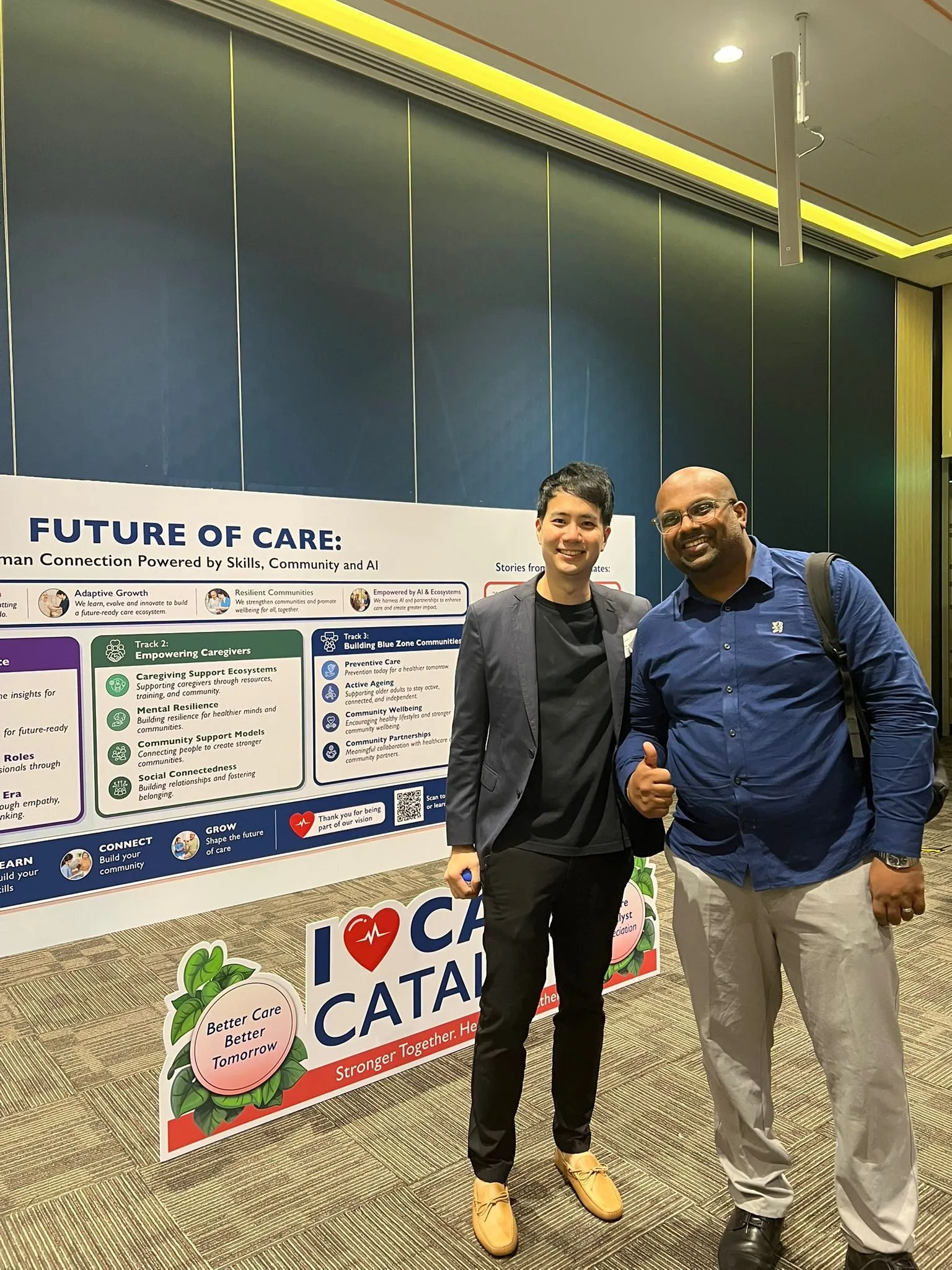 Yau Png Ow with a fellow participant in front of the Future of Care event display